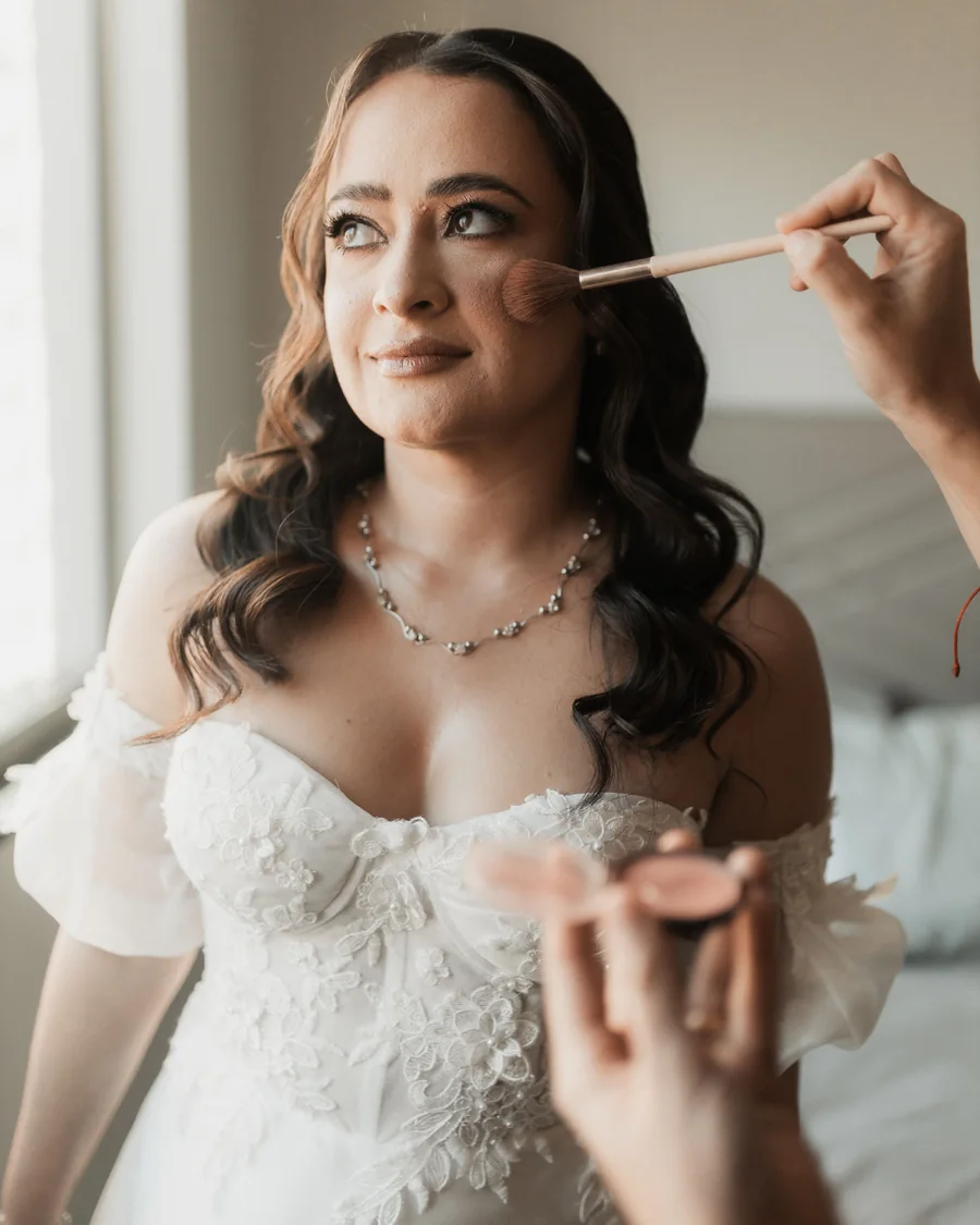 Noiva recebendo maquiagem durante a preparação para o casamento