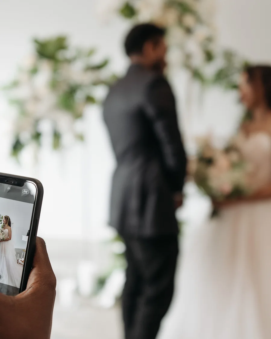 Celular registrando um casal durante uma cerimônia de casamento