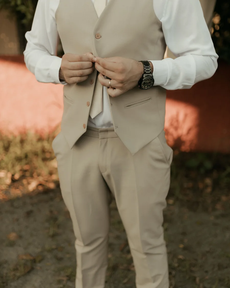 Homem ajustando o colete do traje para uma celebração